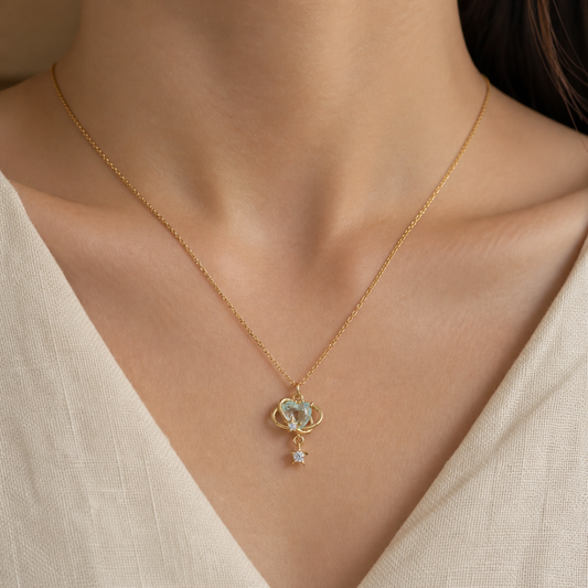 Aqua orbit star drop necklace worn with an ivory V-neck top