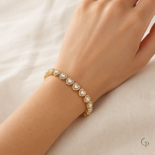 Gold-color clear-stone heart-link bracelet worn on an anonymous wrist