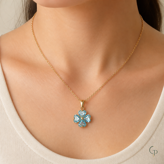 Aqua four-leaf clover pendant necklace worn with a cream neckline
