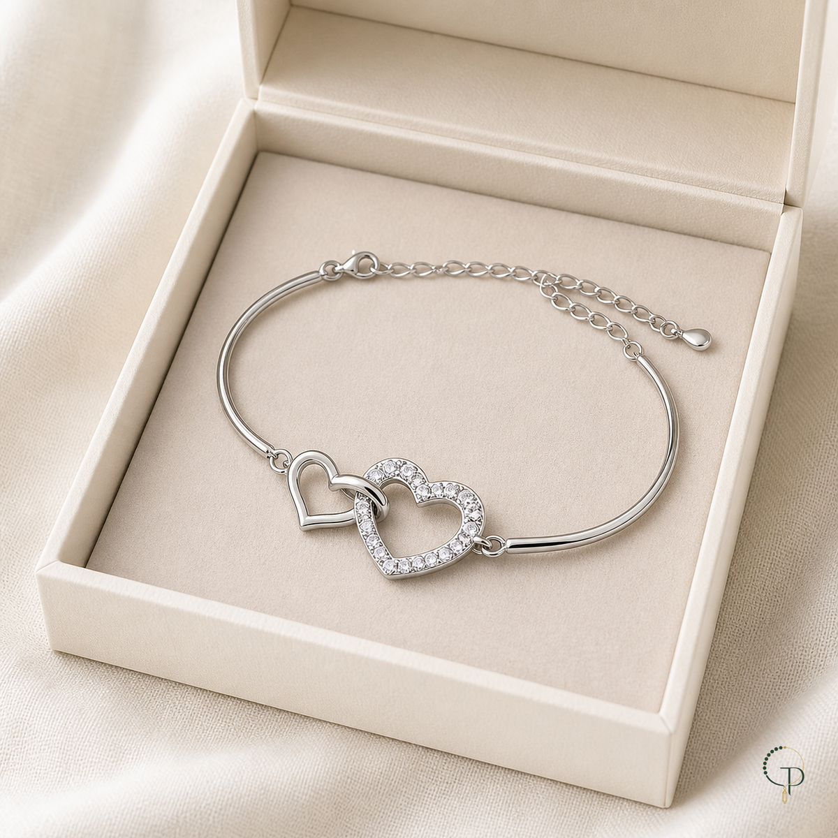 Interlocking double-heart bracelet displayed in an unbranded ivory jewelry box