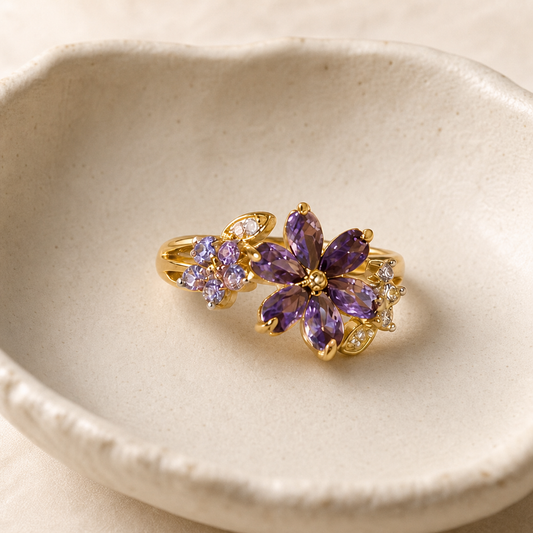 Three-quarter view of purple flower cluster ring in an ivory ceramic dish