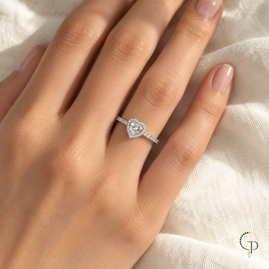 Silver-color heart halo ring worn on a hand against soft ivory linen.