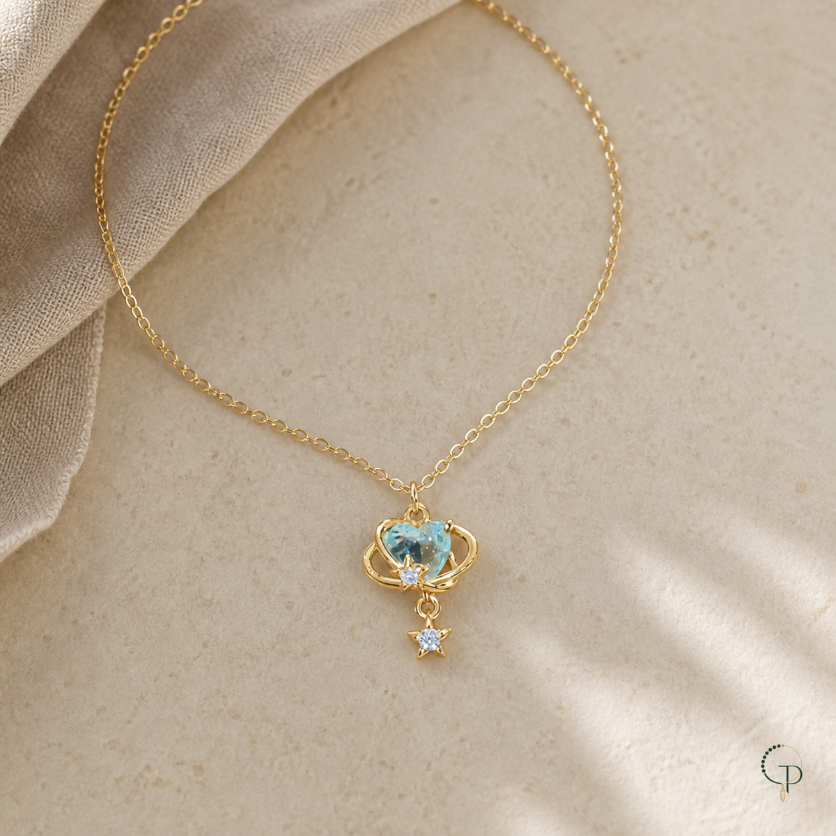 Aqua orbit star drop necklace arranged on warm ivory stone with Gemmy Pocket logo