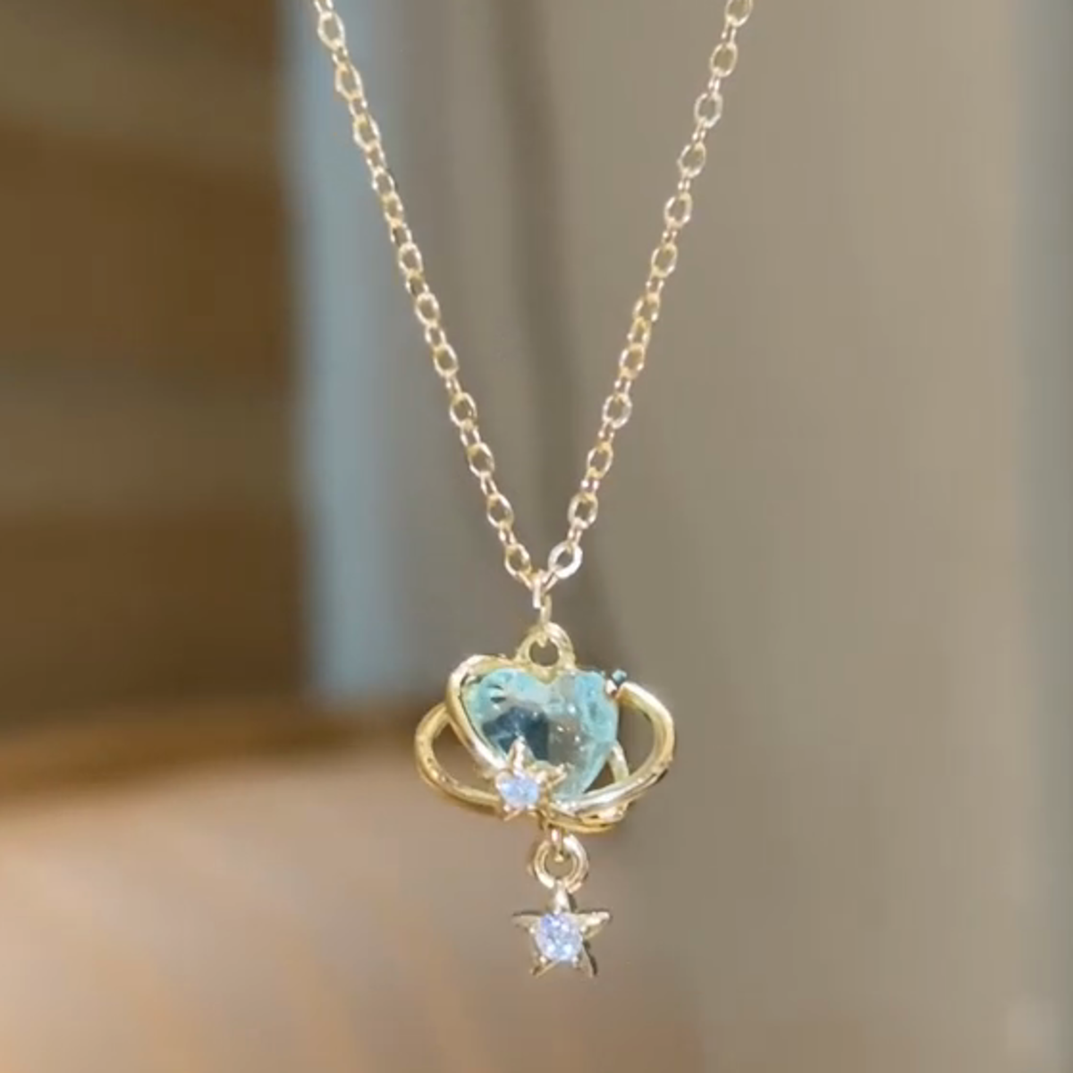 Close view of pale aqua center, gold-color orbit lines and star-shaped dangle