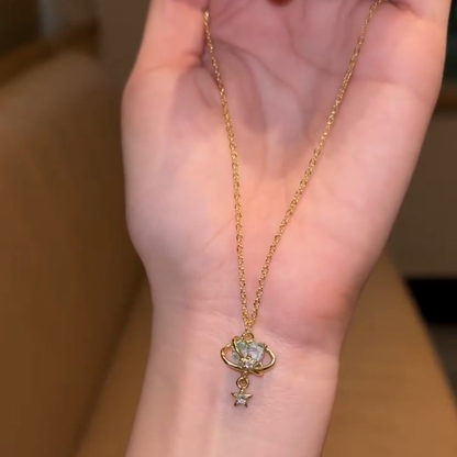 Aqua orbit star drop necklace displayed against a hand for visual scale