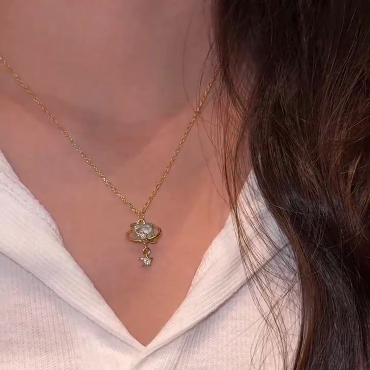Source-video view of the aqua orbit star drop necklace worn at the neckline