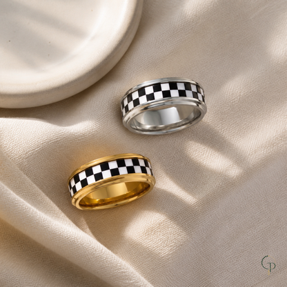 Silver-color and gold-color checkerboard rings arranged on warm ivory linen