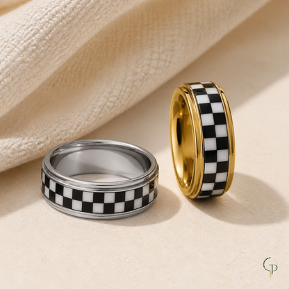 Checkerboard spinner ring interior and edge-rail construction in silver-color and gold-color finishes