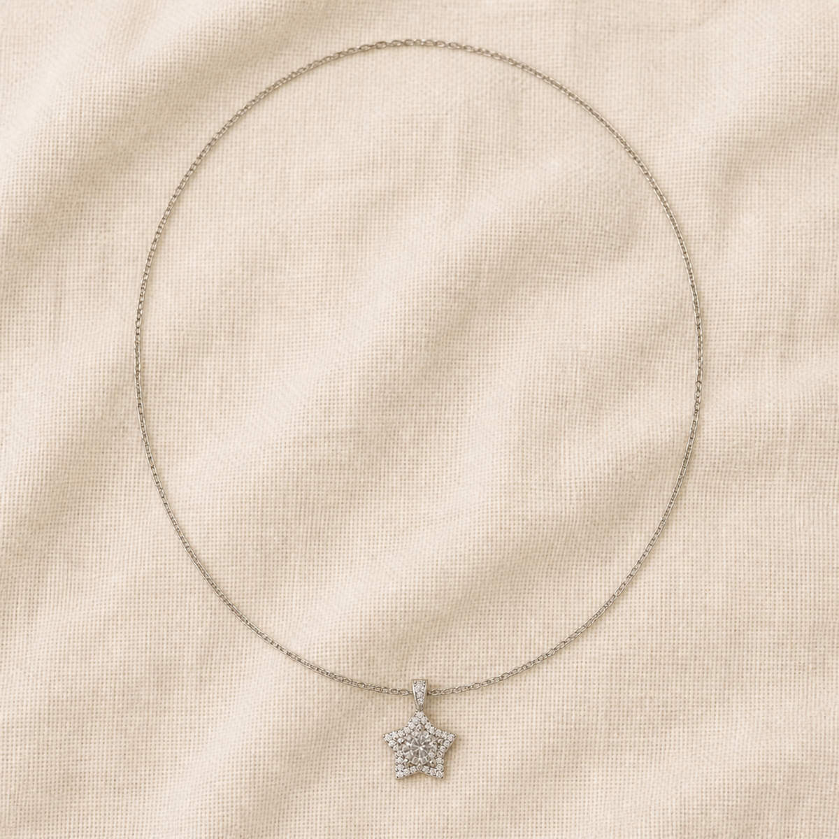 Full silver-color star pendant necklace arranged on oatmeal linen