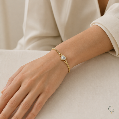 Gold-color heart bracelet shown at wrist scale with a cream sleeve