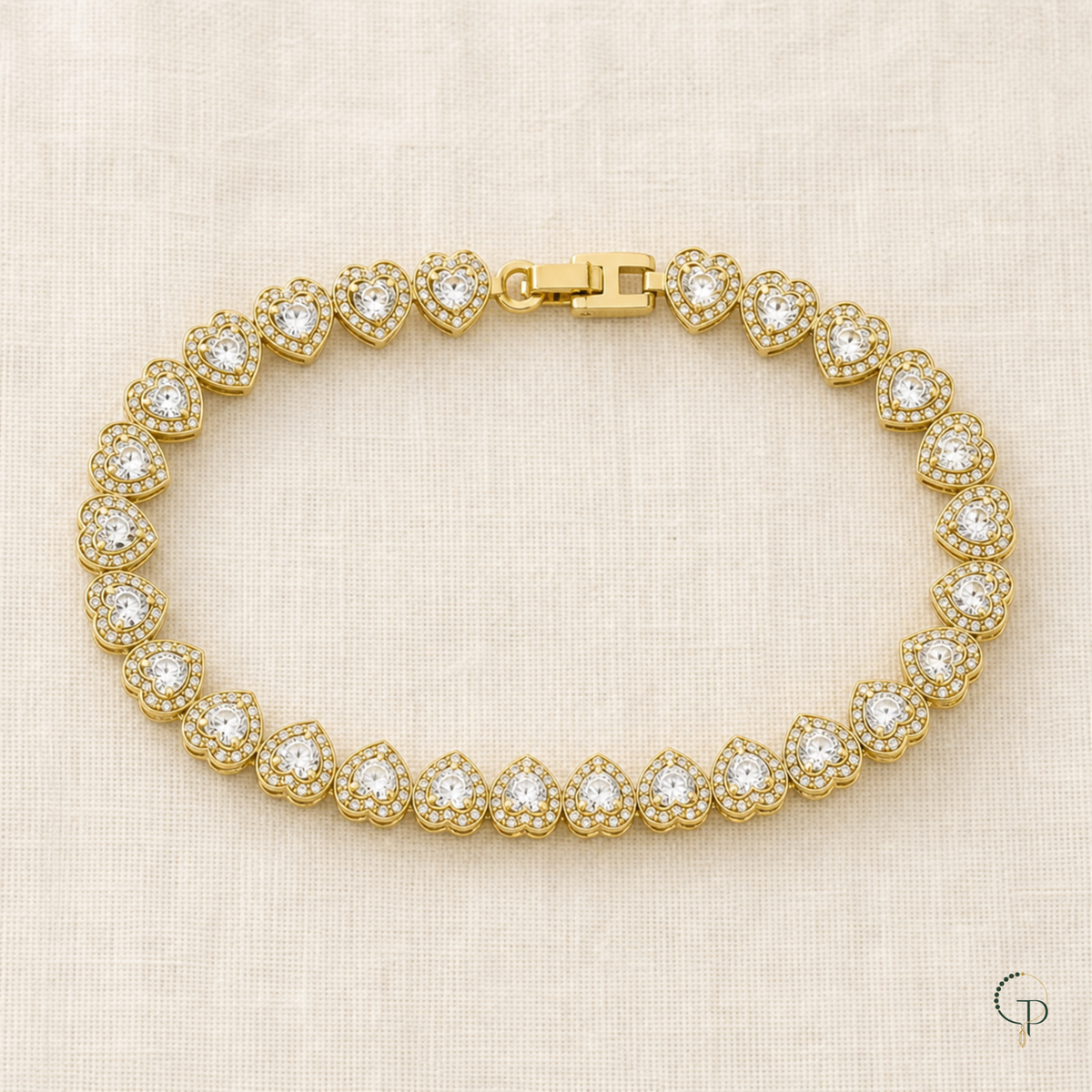Complete gold-color heart-link bracelet arranged on ivory linen
