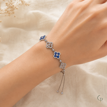 Blue and clear-stone five-motif clover slider bracelet worn around a wrist