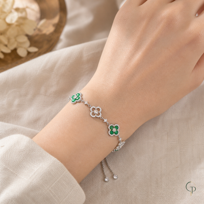 Green and clear-stone five-motif clover slider bracelet worn around a wrist