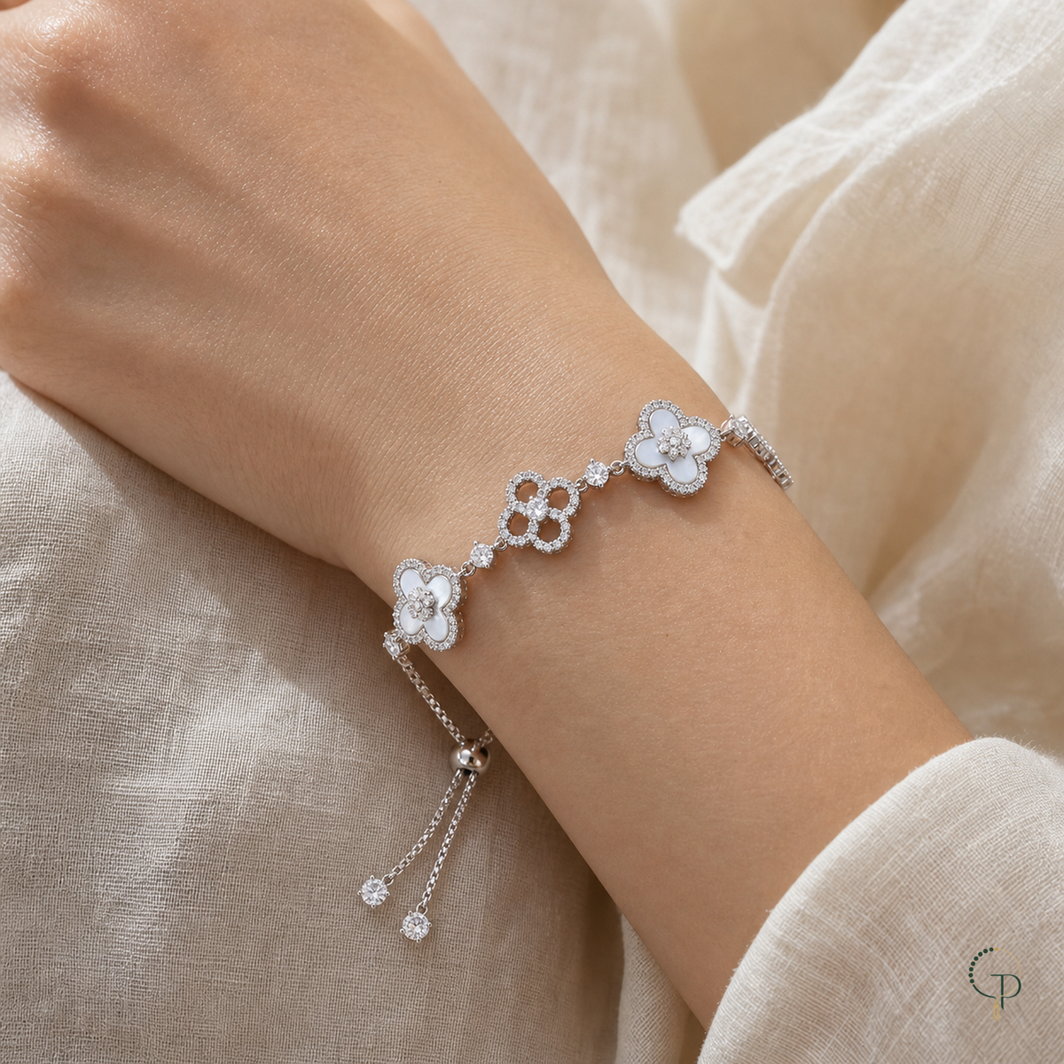 White and openwork five-motif clover slider bracelet worn around a wrist