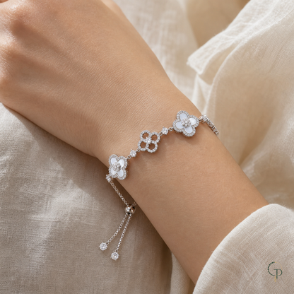 White and openwork five-motif clover slider bracelet worn around a wrist