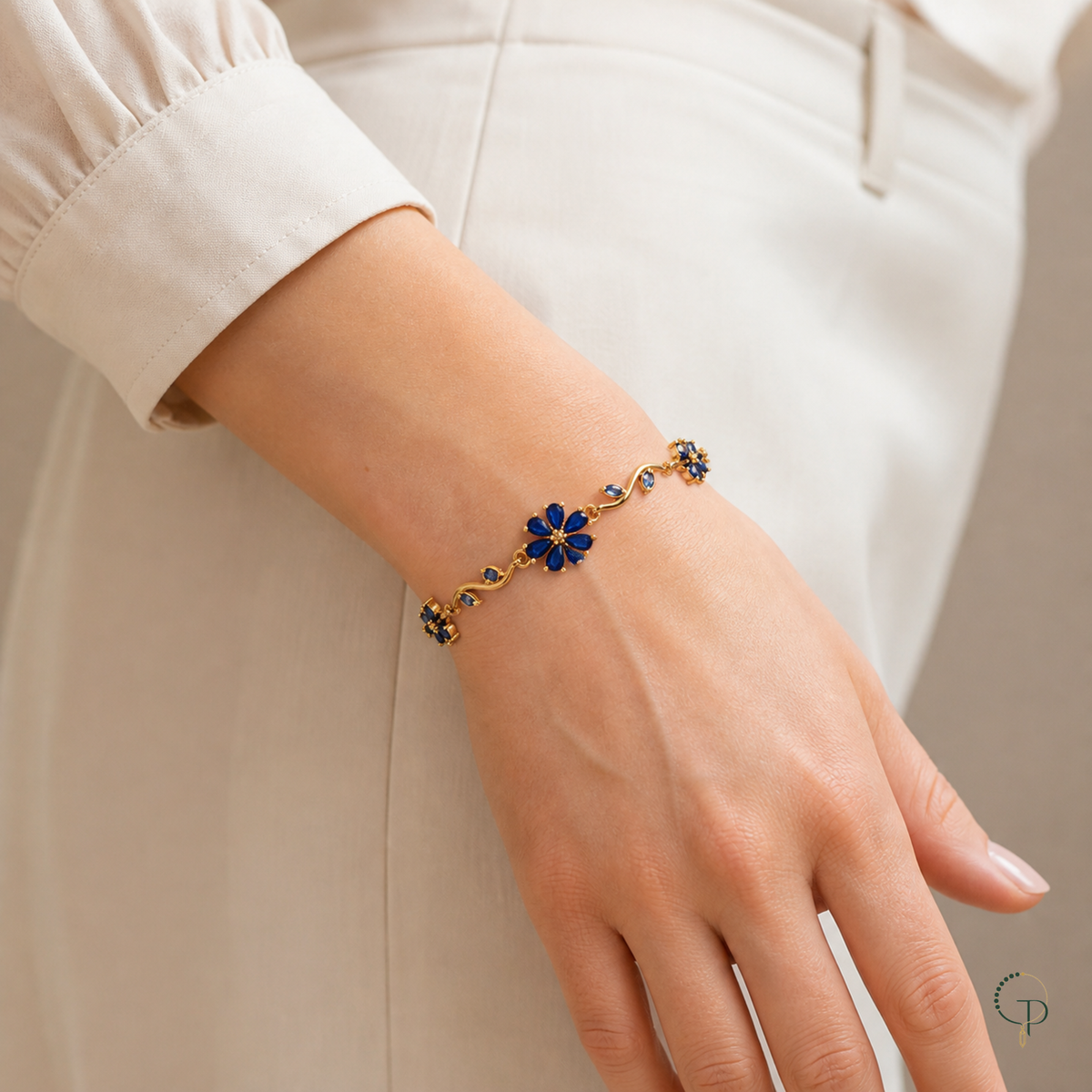 Blue flower vine bracelet shown at wrist scale with a neutral cream sleeve