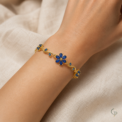 Worn detail of the six-petal blue flower and curved gold-color vine