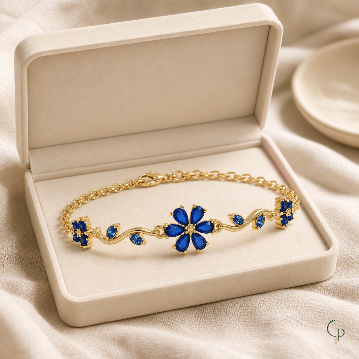 Floral bracelet in an open ivory display box on oatmeal linen
