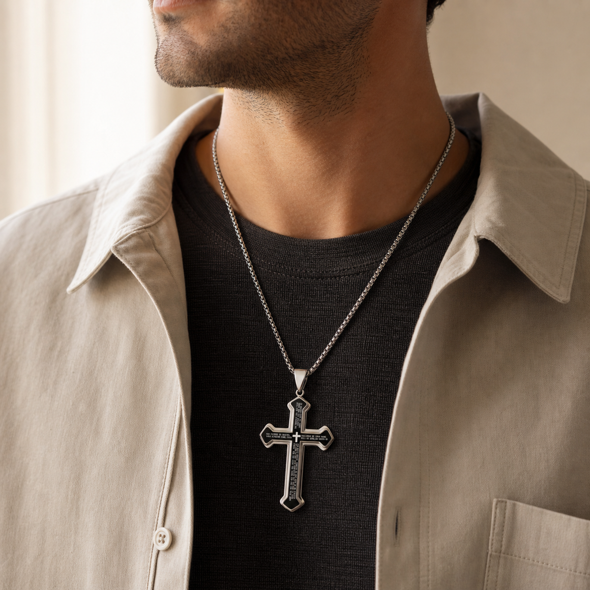Unisex Our Father cross pendant necklace worn with a neutral layered outfit