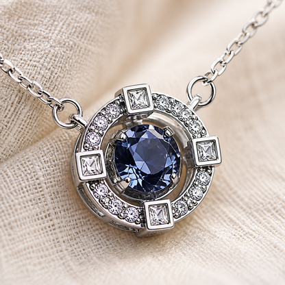 Close-up of silver-color halo pendant with blue center crystal and square accents