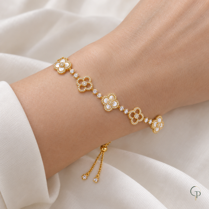 Golden slider bracelet with alternating ivory-filled and openwork clovers worn around a wrist