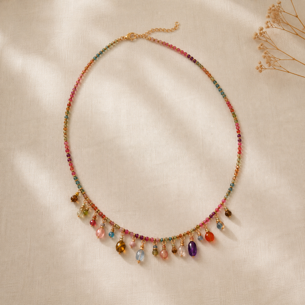 Full multicolor beaded charm necklace arranged on ivory linen