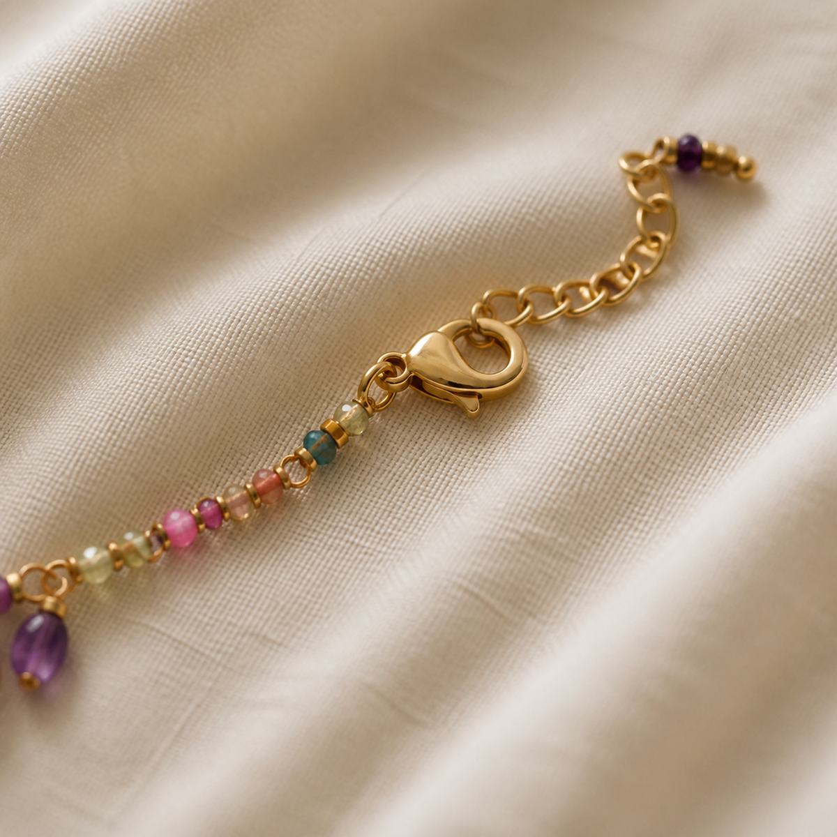 Close-up of lobster clasp and extension chain on beaded charm necklace