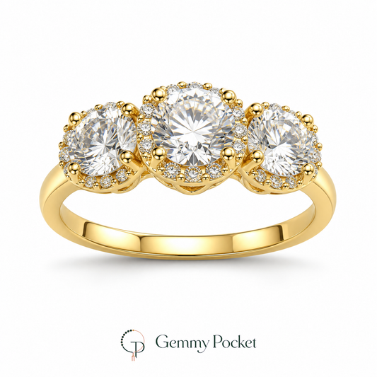 Gold-color graduated three-stone halo ring on a white studio background