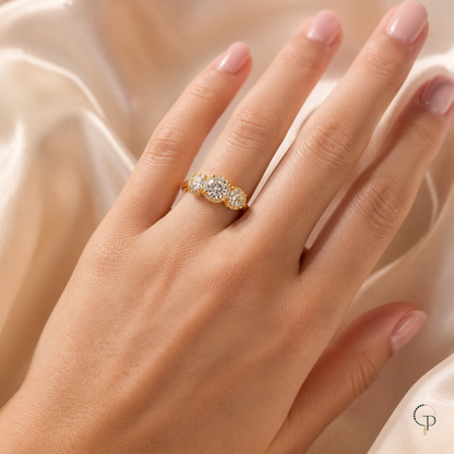 Graduated three-stone halo ring worn on an anonymous hand