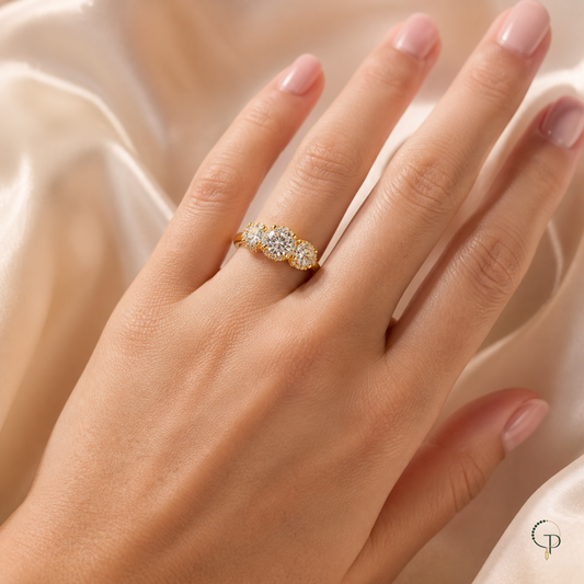 Graduated three-stone halo ring worn on an anonymous hand
