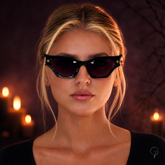 Halloween black cat-eye sunglasses worn in a smoky purple and amber editorial portrait
