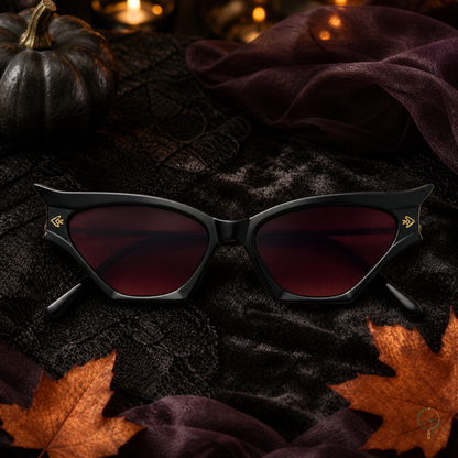 Halloween black cat-eye sunglasses styled with black lace, dark leaves and a matte pumpkin
