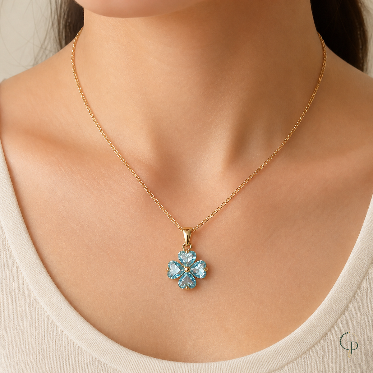 Aqua four-leaf clover pendant necklace worn with a cream neckline