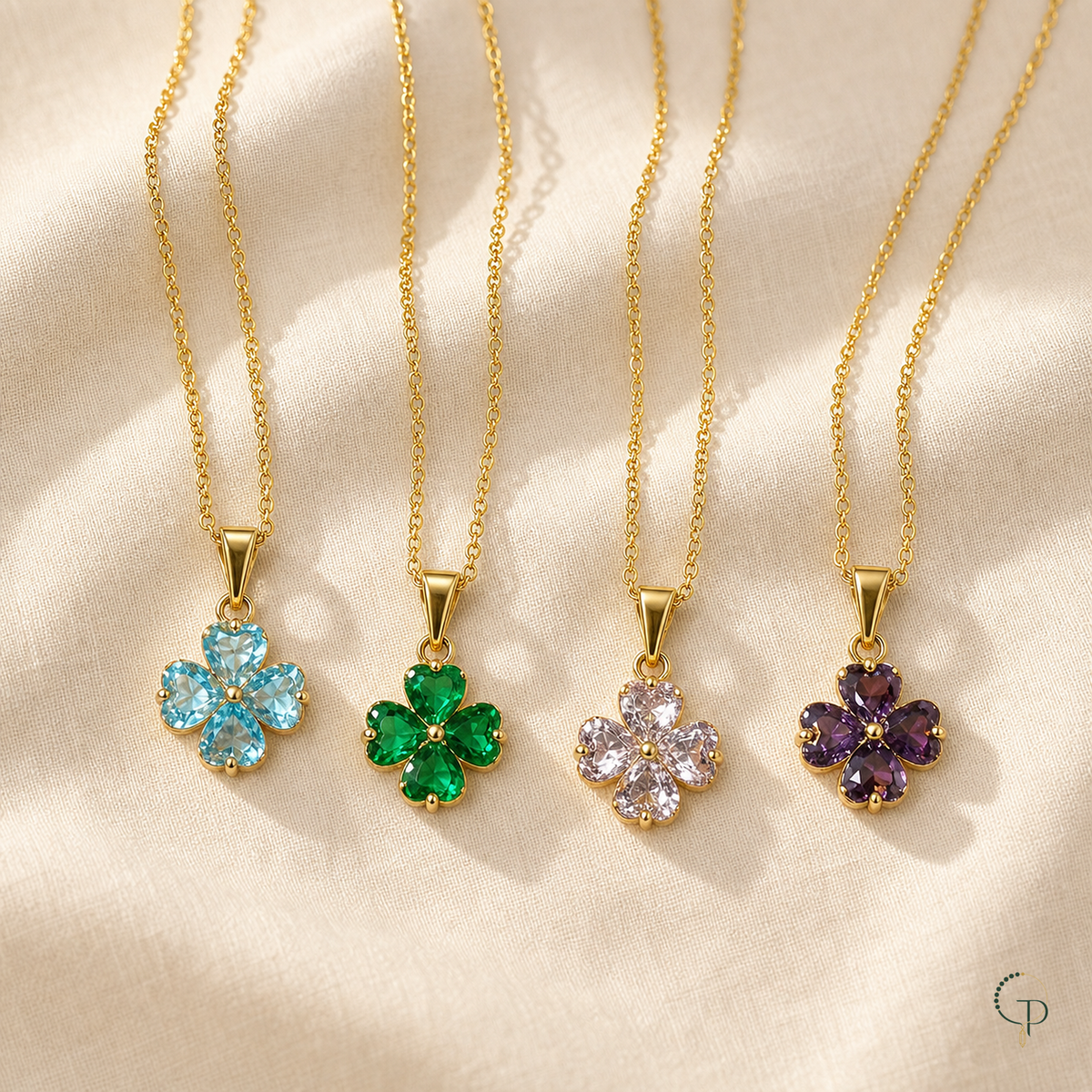 Aqua, emerald green, clear blush and purple clover pendant necklaces arranged on ivory linen