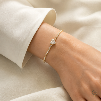 Heart stone cuff bracelet worn at the wrist with an ivory sleeve.