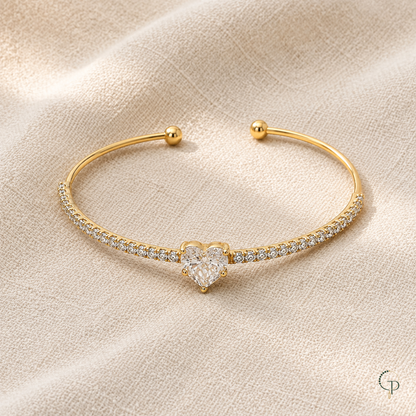 Full gold-color heart cuff bracelet on oatmeal linen with rounded open ends visible.