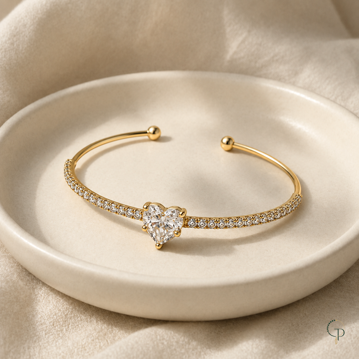 Heart stone cuff bracelet displayed on an ivory ceramic dish with cream linen.
