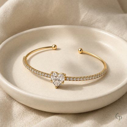 Heart stone cuff bracelet displayed on an ivory ceramic dish with cream linen.
