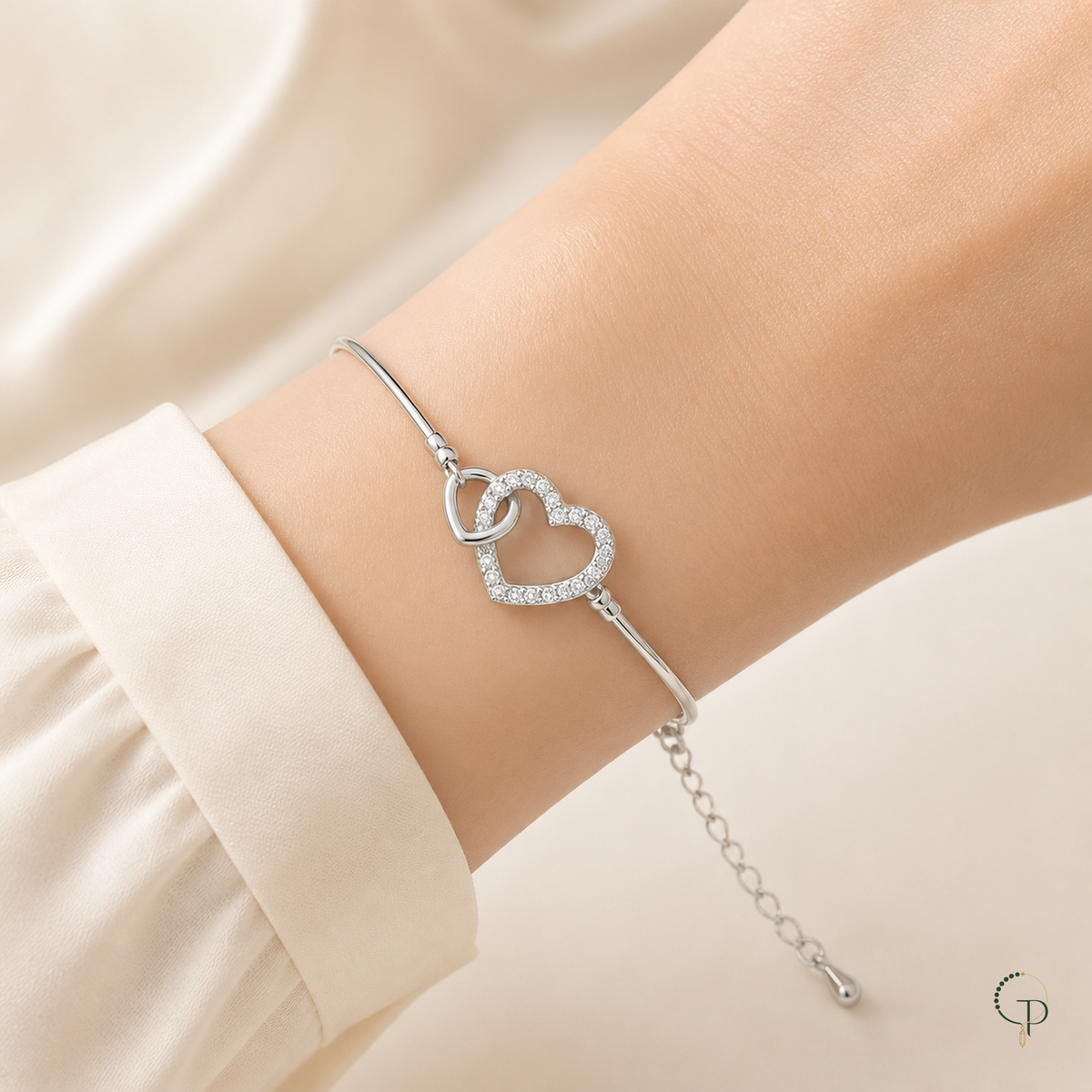 Silver-color interlocking double-heart bracelet worn on an anonymous wrist