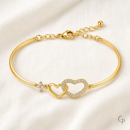 Complete gold-color two-heart bracelet arranged on ivory linen