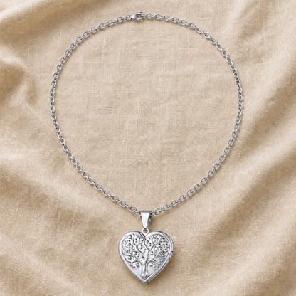 Silver tree of life heart locket necklace on warm ivory linen