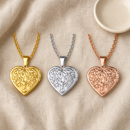 Three tree of life heart lockets beside an ivory ceramic dish