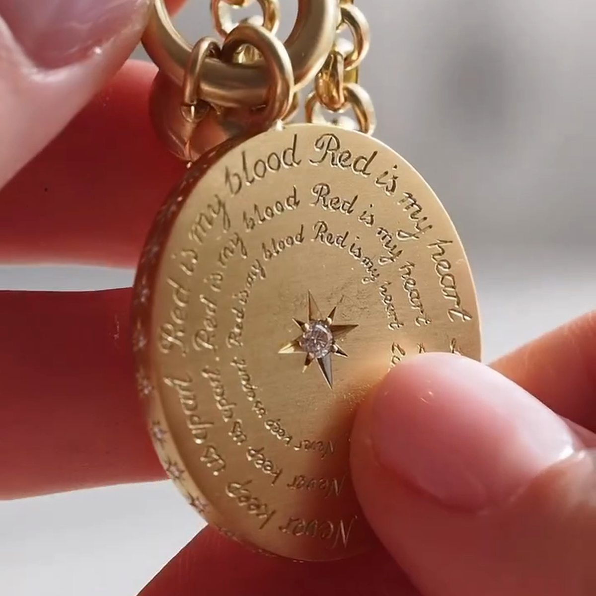 Reverse of oval medallion with circular lettering and central star-set clear stone