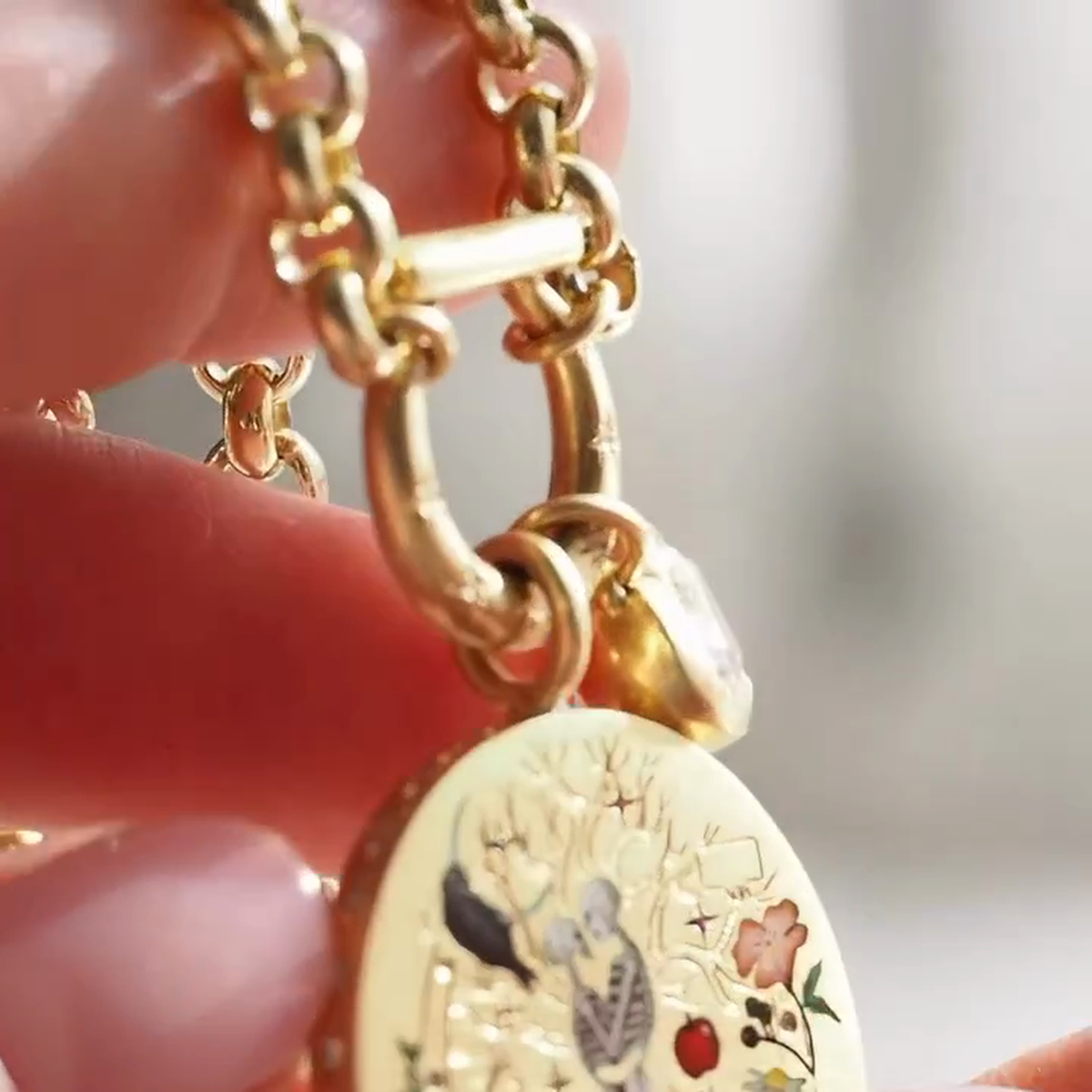 Detail of star-decorated circular clasp and clear heart-shaped charm