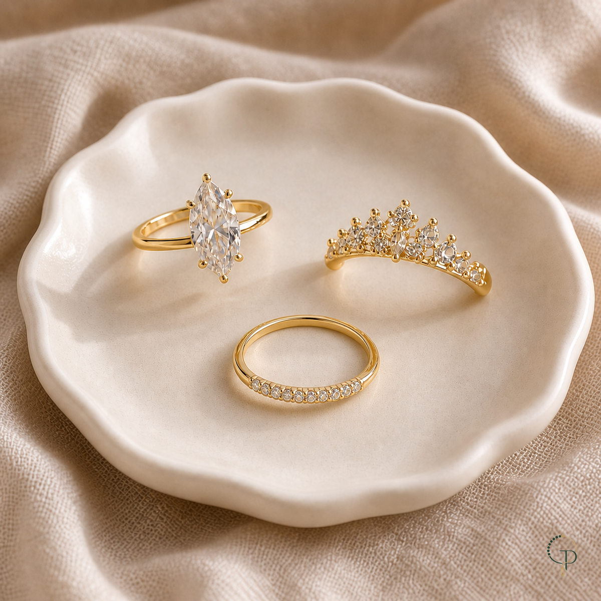 Three-piece marquise crown stacking ring set arranged in an ivory ceramic dish