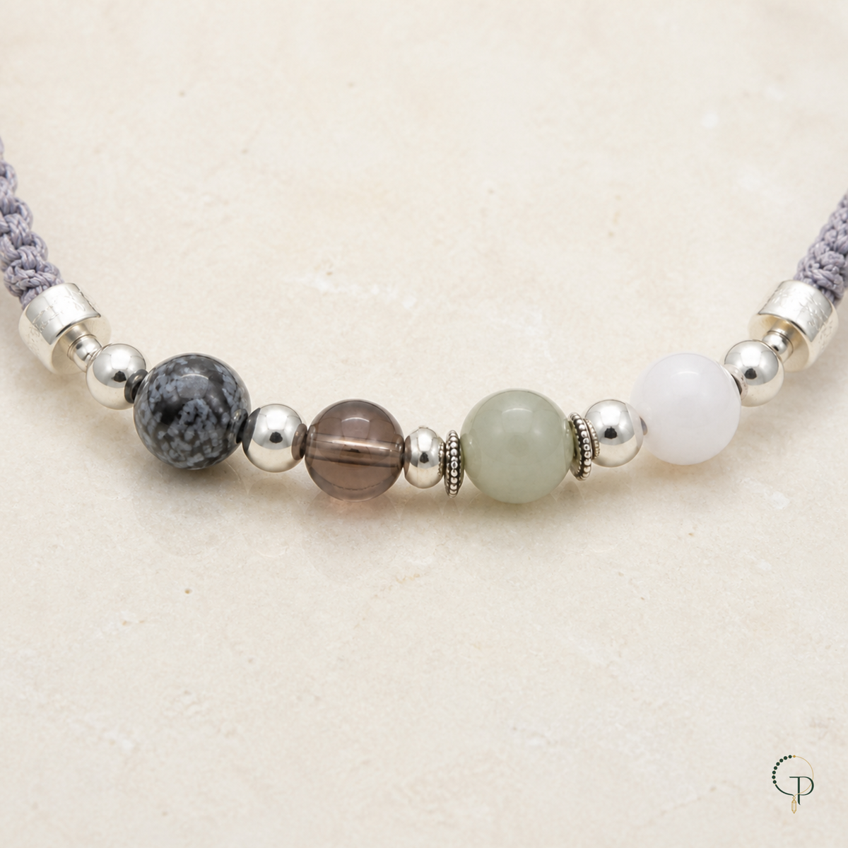 Close view of white, sage, smoky brown and patterned beads with silver-color spacers