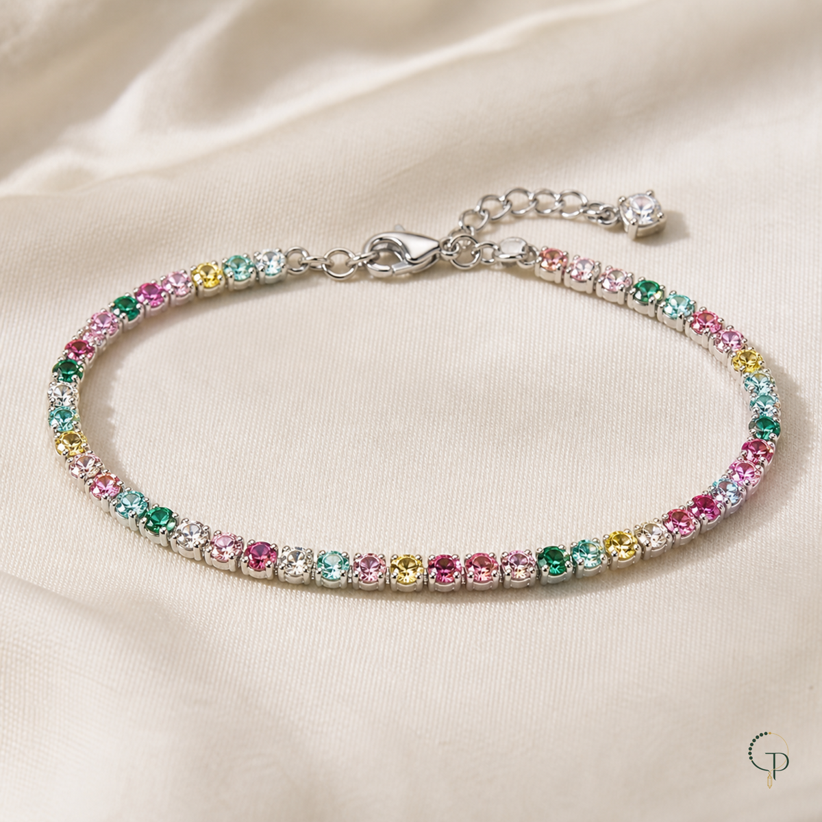 Three-quarter view of the silver-color multicolor tennis bracelet on ivory linen