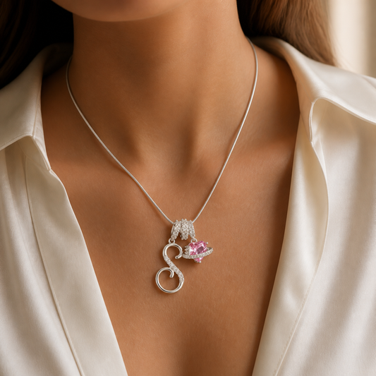 S charm and pink planet necklace worn with an ivory blouse
