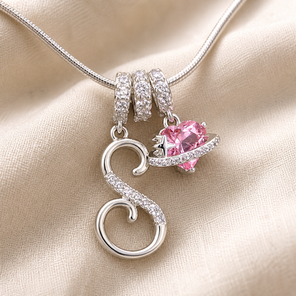 Close view of S-shaped and pink stone planet pendants