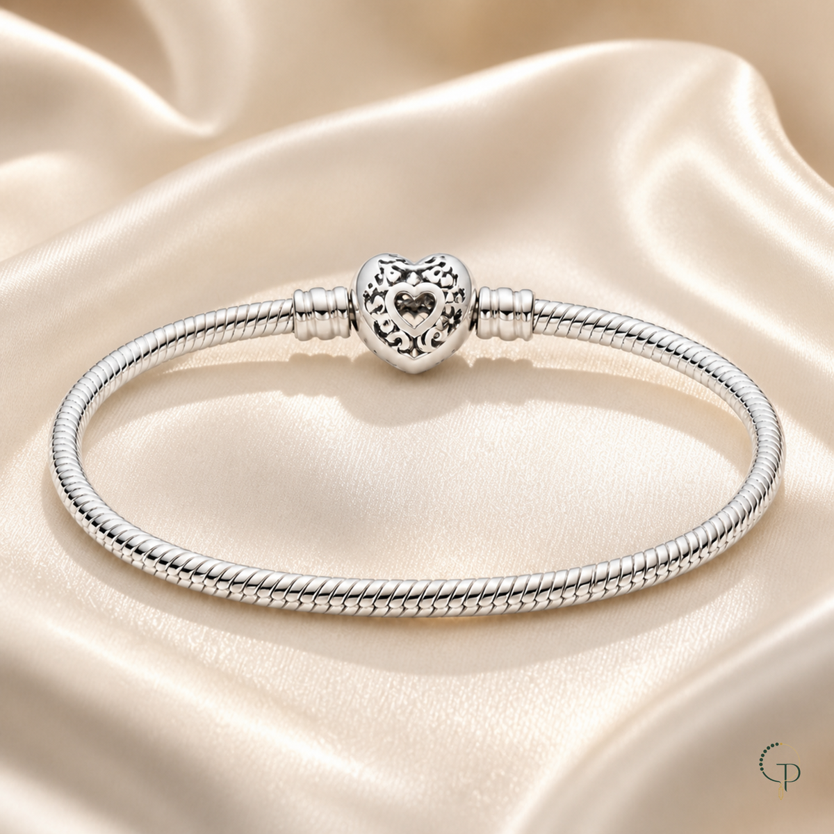 Openwork heart clasp snake-chain bracelet styled on cream satin